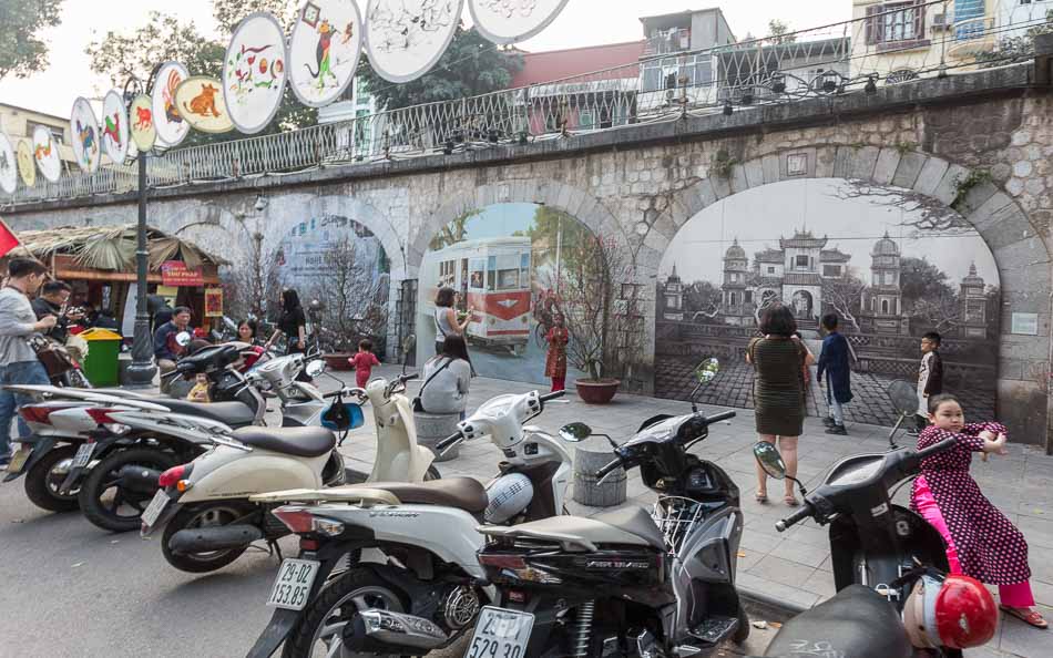 Pessoas fotografando os murais da rua Phung Hung